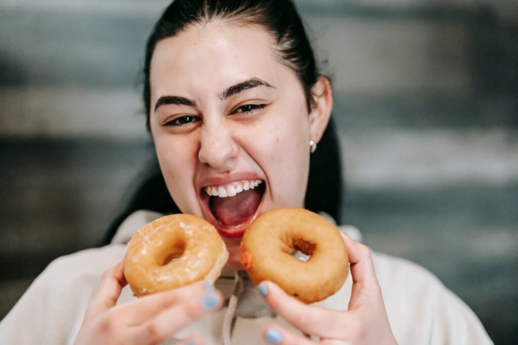 Femme affamée avec de délicieux beignets à la maison