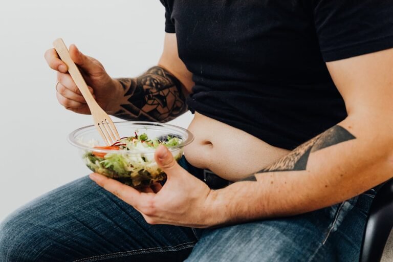 un homme tatoué tenant une salade de légumes frais